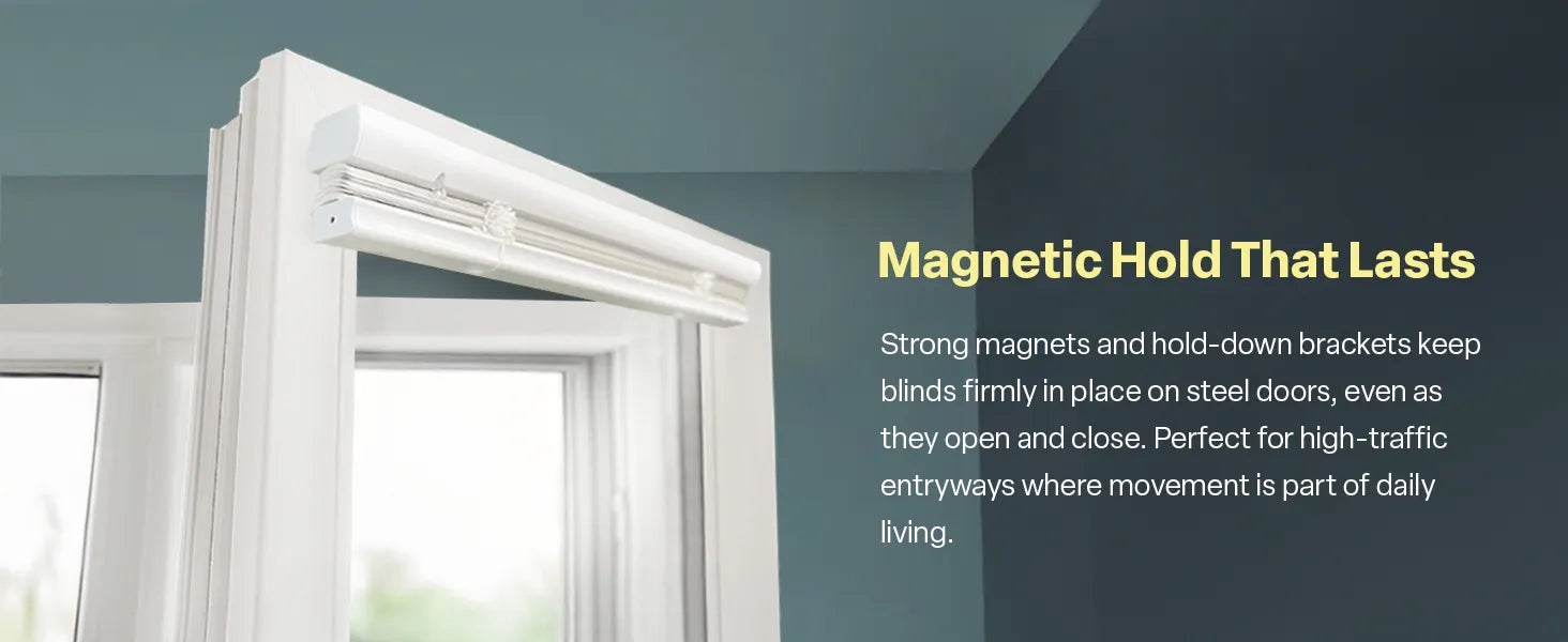 A close-up view of white blinds mounted to the top of a steel door frame against a dark teal wall. The text "Magnetic Hold That Lasts" explains that strong magnets and hold-down brackets keep the blinds firmly in place during daily movement, making them perfect for high-traffic entryways.